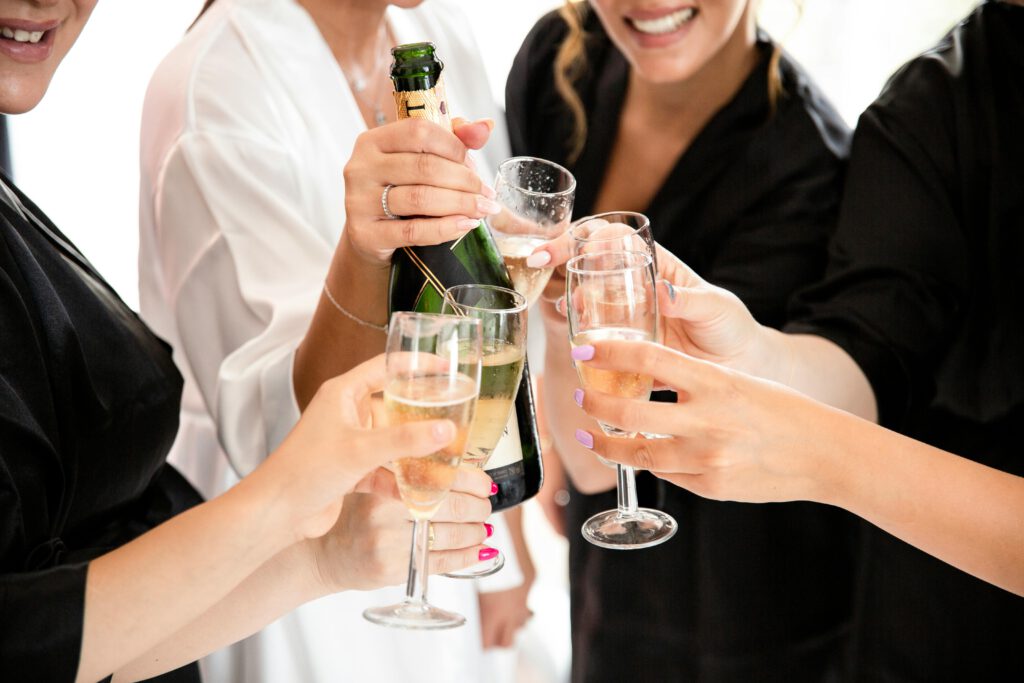 A group of women toasting with champagne glasses in a festive celebration.